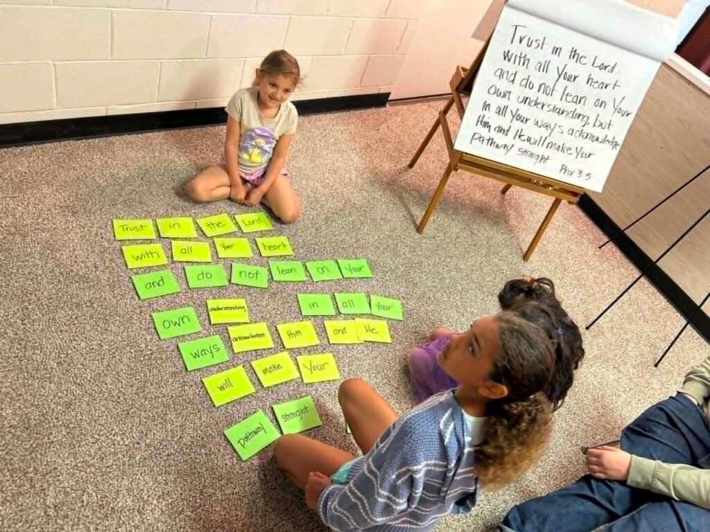A smiling girl with the memory-verse word cards during Children's Church
