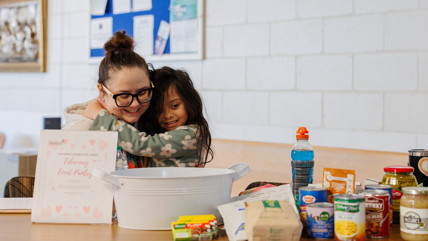 A volunteer welcoming a family at the PCOC Food Pantry